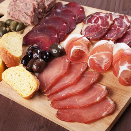 Chopping board of Tuscan specialties with cured meats, bruschetta, olives and local produce, perfect for an authentic food tasting.